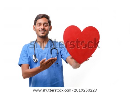 Young male doctor holding a beautiful red heart shape in hand