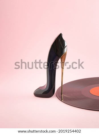 Women's shoe with high-heeled shoes and vinyl on a pastel pink background. Minimal creative abstract visual music art idea. Retro disco party concept.