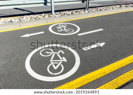 City street asphalt road with separated two way direction bicycle lane route sign mark with white paint. Modern eco urban commute transportation infastrucutre organization. Healthy lifestyle concept