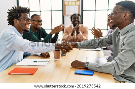 Group of african american business workers smiling and clapping to partners handshake at the office. Royalty-Free Stock Photo #2019273542