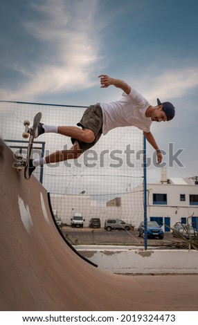 young man skateboarding on the ramp of a skate park. vertical composition