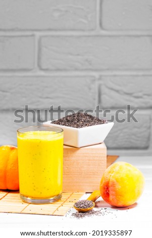 Still life with fruit smoothie, peach and chia seeds on r white brick background, vertical resolution, Healthy summer diet, Copy Space