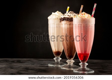 Three glasses of milkshake with assorted flavors. Chocolate, vanilla and strawberry milkshake. Royalty-Free Stock Photo #2019356306