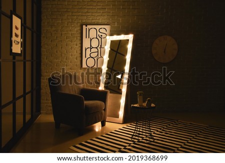Interior of modern room with comfortable armchair and mirror