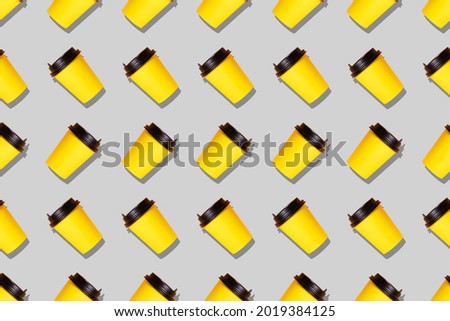 Seamless pattern of illuminating yellow paper coffee cups on the ultimate gray background, colors 2021