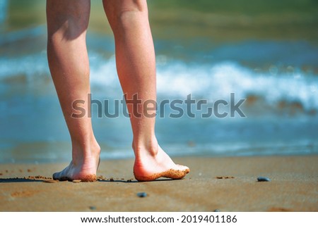 Portrait of beautiful young girl standing against blue sea water. 