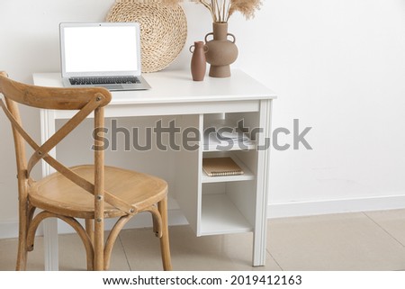 Comfortable workplace near light wall in room