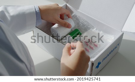 Close-up hand asia woman chemist help pack covid free first aid self recover care on desk give for customer people buy online clinic retail Rx drug store in telehealth telemedicine e-commerce order. Royalty-Free Stock Photo #2019425741