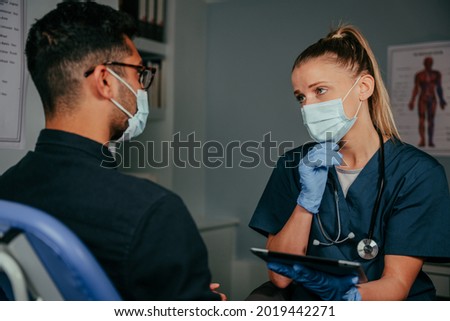 Mixed race male patient chatting to female nurse