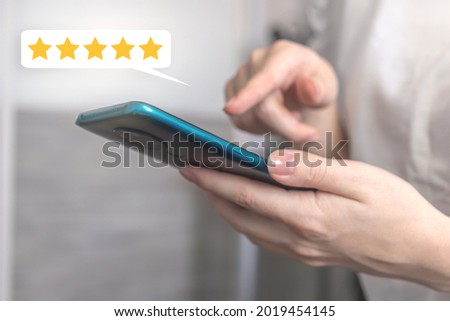 Woman touch the screen with five star rating, rate the service with feedback concept, customer with the mobile phone