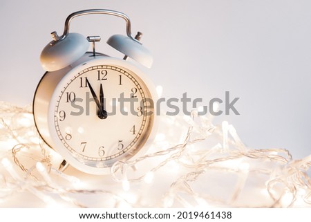 large clock showing 12 o'clock on a uniform blue background with place for text christmas theme. High quality photo Royalty-Free Stock Photo #2019461438