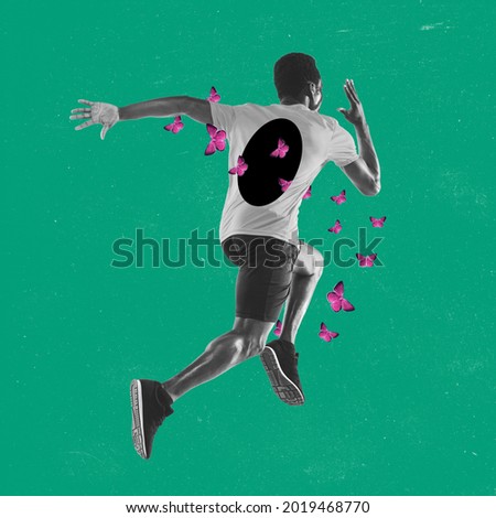 BW image of young man, athlete running away with pink butterflies flying through his body over green background. Inspiration, creativity and sports concept