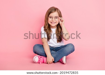 Photo of dream funny little girl sit floor wear glasses white t-shirt jeans shoes isolated pink color background Royalty-Free Stock Photo #2019472835