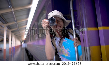 Young girl tourists smile and use camera take a photo travel photography on the train while waiting for the train to travel. Freedom active lifestyle concept.