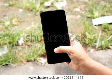 hand holding phone with nature background