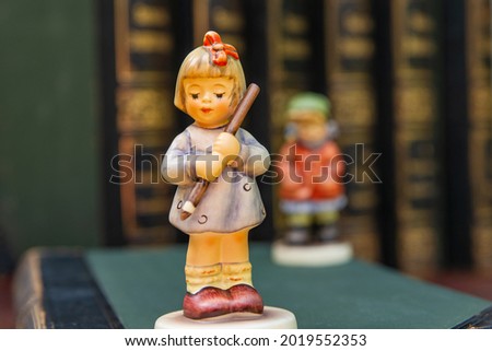 Pretty girl  figurine on old book background. Student figurine on an  book. First grader. Beginning of the school year
