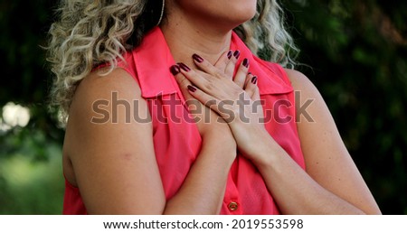 Latina woman putting hand on chest smiling taking a deep breath feeling GRATITUDE