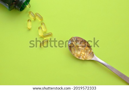omega 3 dietary supplement is poured out of the package into a spoon