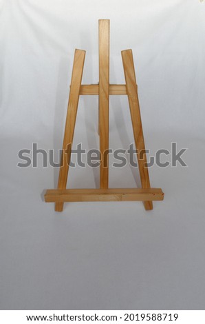 Wooden folding tabletop three-legged painting easel on fabric white background