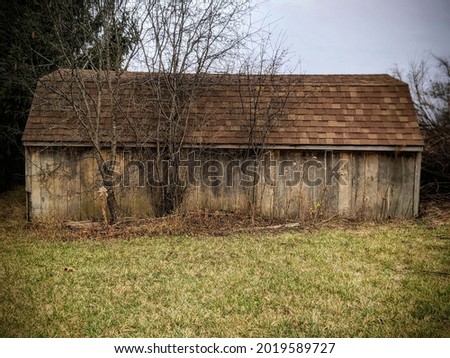 Picture of an old unpainted decaying barn on a  grey Autumn day