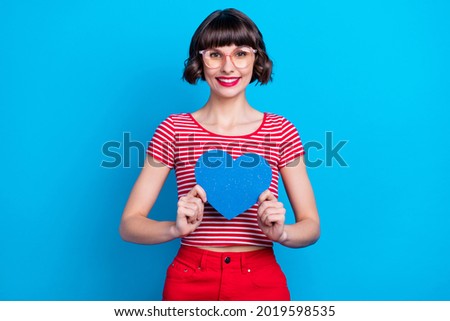 Photo portrait girl in glasses smiing showing heart isolated vivid blue color background Royalty-Free Stock Photo #2019598535