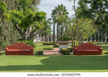 Terracotta colored concrete benches with trees in the background and blue sky