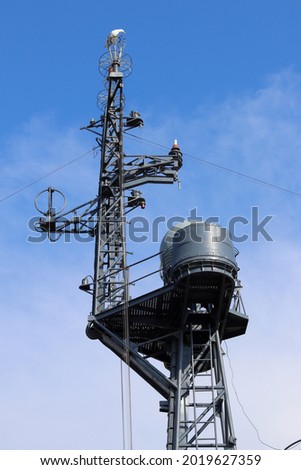 The mast of a modern warship against the background of the blue sky