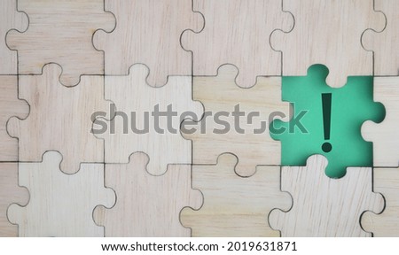 Missing pieces of jigsaw puzzle with notification mark symbol. Conceptual image