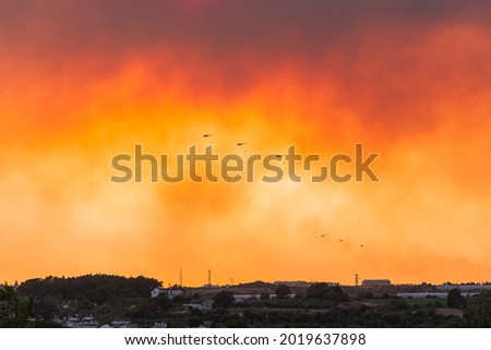 Massive Red, Orange Fire Smoke over the city, fire fumes, fire helicopters trying to put out the fire, the day of doom. Royalty-Free Stock Photo #2019637898