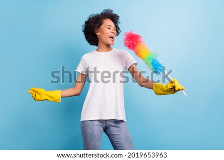 Photo of young excited crazy cheerful dreamy afro girl cleaning singing karaoke isolated on blue color background