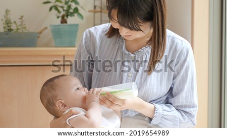 Mother gives milk to her baby Royalty-Free Stock Photo #2019654989