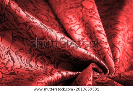 red silk fabric with flower pattern, beautiful appearance, unique shine; embossed pattern, composite textile. relief pattern