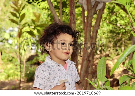 Close up portrait of A small Asian child standing in the garden thinking about Nature and eco