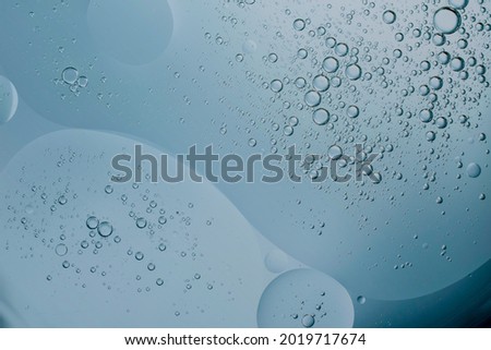 oil drop floating or Cosmetic liquid  serum on the water blue bubbles background