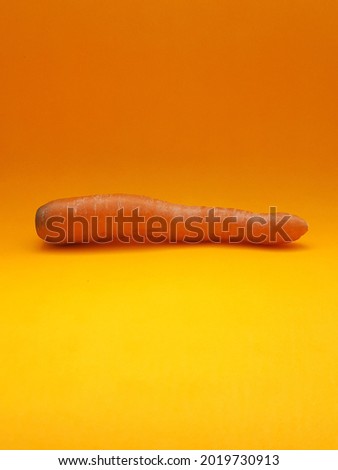 carrot photographed on an orange background