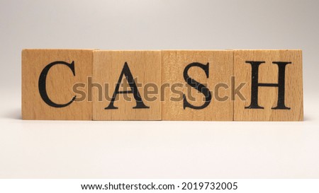 The name Cash was created from wooden letter cubes. finance and economy. close up.