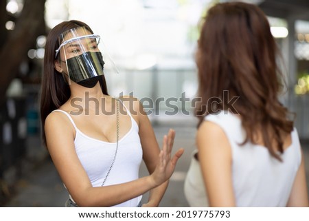 Careful woman with face mask asking no masker to stay away Royalty-Free Stock Photo #2019775793