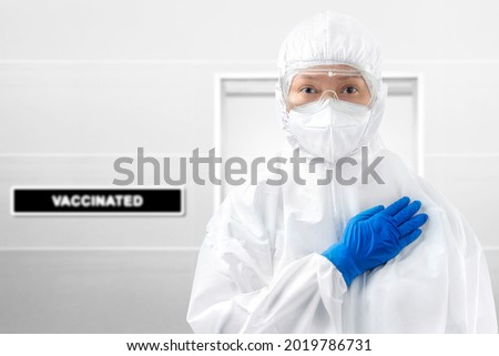Health worker woman with a protective suit and gloves standing on the hospital