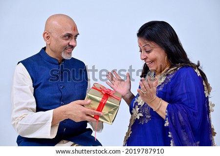 Senior couple, husband giving gift to wife 