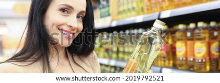 Portrait of smiling woman holding sunflower oil in shop