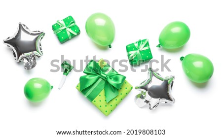 Gift boxes with balloons and noisemaker on white background