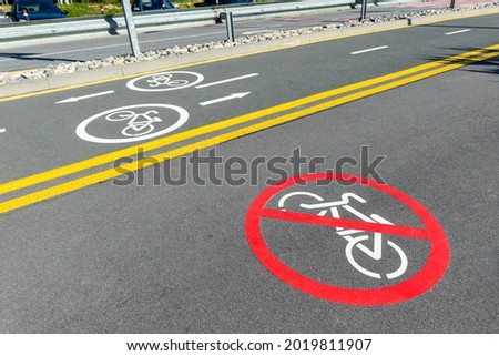 City street asphalt road with separated two way direction bicycle lane route sign mark and bike riding prohibited symbol. Modern eco urban commute transportation infastrucutre organization.