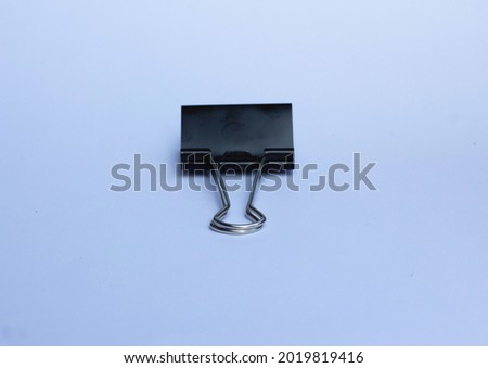 black paper binder clip isolated on a white background. the concept of copy space and selective focus.