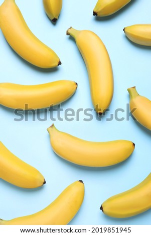 Sweet ripe baby bananas on turquoise background, flat lay