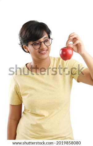 young girl holding an apple.