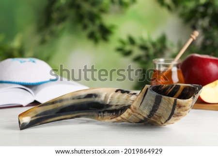 Shofar and other Rosh Hashanah holiday attributes on white wooden table outdoors Royalty-Free Stock Photo #2019864929