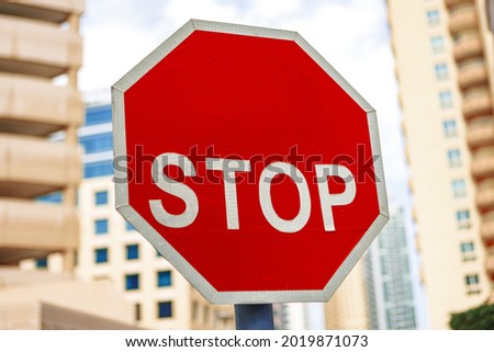 Red stop sign in city close up
