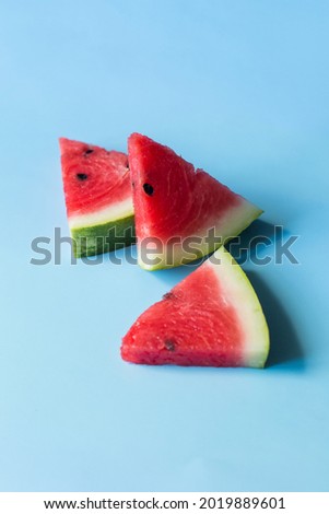 Several slices of fresh watermelon on a blue background