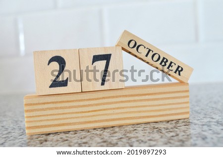 October 27, Cover design with number cube on a white background and granite table.