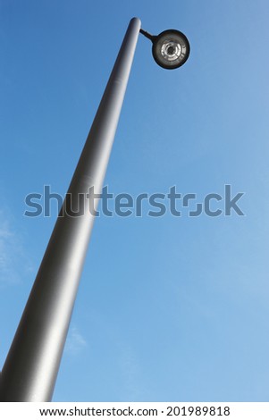 Modern street lamp under a blue sky. Vertical format